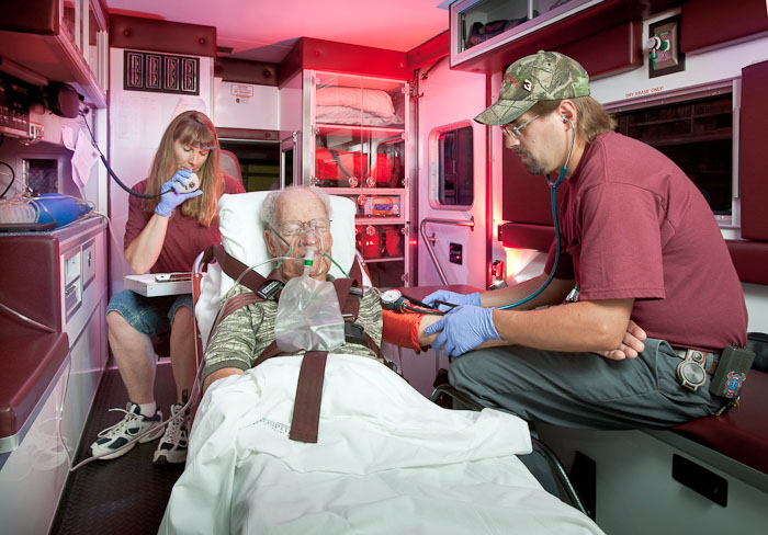 EMTs with patient inside ambulance