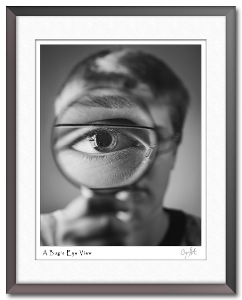 Boy looking through a magifying glass