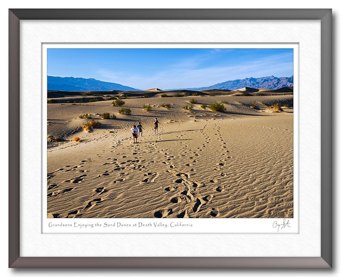 Three boys running in the sand dunes at Death Valley